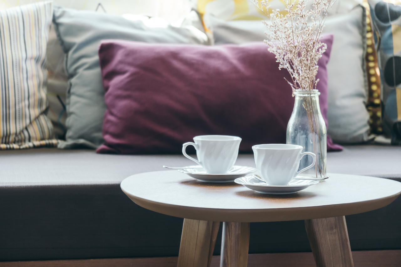 open-airy-living-room-a-beautiful-couch-and-a-coffee-table-with-a-lantern-on-it